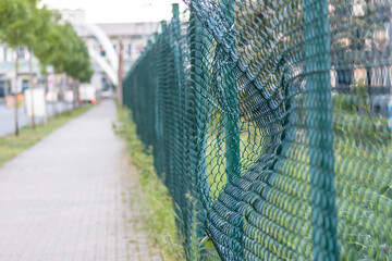 Green damaged wire-mesh fence is ruined after collision with car accident as crushed fence for car...