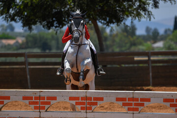 Rider on horse jumping over a hurdle during the equestrian event	