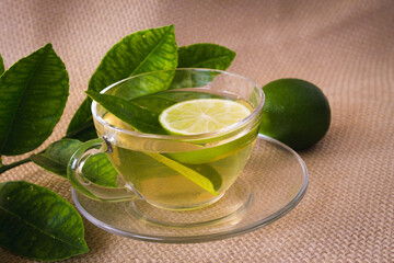 lemon tea in cup of glass on the table with fruit in natural. honey and cinnamon