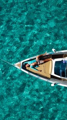 Obraz premium man resting on the deck of a boat in the sea of a beach of Majorca.Concept of holiday, leisure, travel, sun and beach