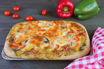 Fresh baked delectable homemade veggie cheesy pesto sauce pizza on the table