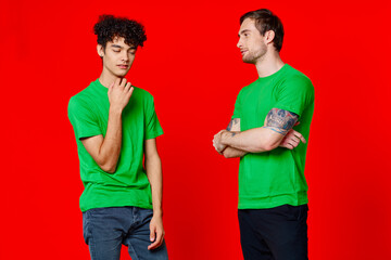 two men in green t-shirts are standing side by side communication isolated background