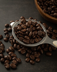 Coffee beans in spoon on grunge background.