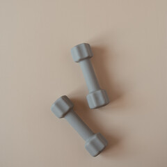 Top view of sport, fitness, yoga, workout equipment. Dumbbells on beige background. Flat lay sport influencer minimalist blog, web, social media. Weight loss concept