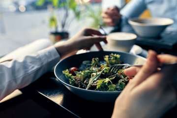 fresh salad in a plate delicious food diet fork in hand female hands cafe