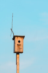 Wooden birdhouse in the garden against the sky