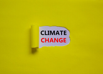 Climate change symbol. Words 'climate change' appearing behind torn yellow paper. Beautiful yellow background, copy space. Business, ecological and climate change concept. Copy space.