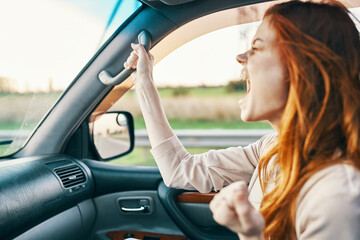 Plakat emotional woman sitting on the front seat in a car salon emotions model