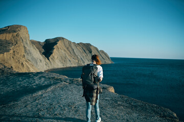 woman with backpack in the mountains in nature back view