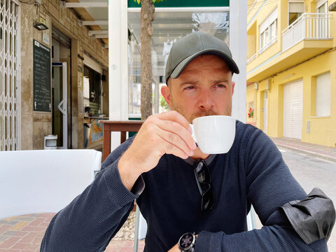 Man sitting at the cafe sipping his coffee