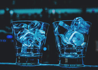 Ice cube in an empty glass on a bar counterin bar or pub