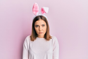 Young beautiful woman wearing cute easter bunny ears skeptic and nervous, frowning upset because of problem. negative person.