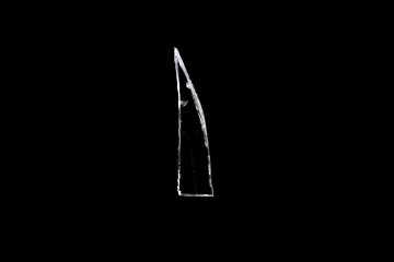 sharp shard of glass insulated against a black background