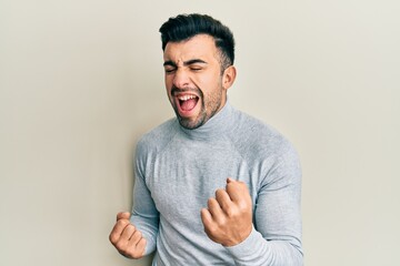 Young hispanic man wearing casual clothes celebrating surprised and amazed for success with arms raised and eyes closed