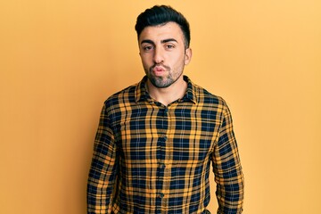 Fototapeta premium Young hispanic man wearing casual clothes looking at the camera blowing a kiss on air being lovely and sexy. love expression.