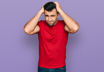 Hispanic man with beard wearing casual red t shirt suffering from headache desperate and stressed because pain and migraine. hands on head.