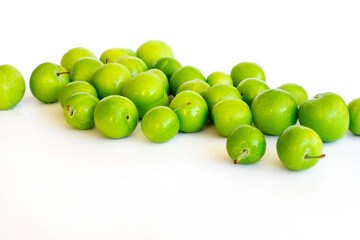 Pile of green plum fruit isolated on white