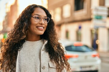 Young latin woman smiling happy standing at the city.