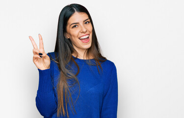 Young hispanic woman wearing casual clothes showing and pointing up with fingers number two while smiling confident and happy.