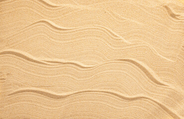 Fototapeta na wymiar Summer beach concept. Yellow beach sand with wave pattern.