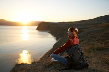 pretty woman tourist with backpack admiring the landscape sunset vacation
