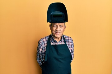 Repair man wearing professional welding mask over head covering face for protection