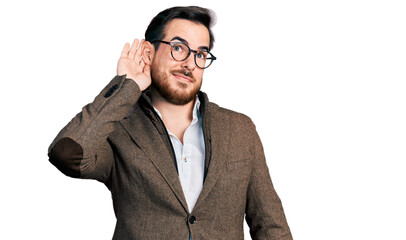 Young hispanic man wearing business jacket and glasses smiling with hand over ear listening an hearing to rumor or gossip. deafness concept.