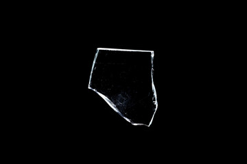 glass fragments in isolation on a black background. damaged window. damaged object