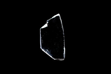 glass fragments in isolation on a black background. damaged window. damaged object