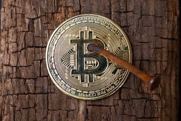 Bitcoin nailed to wood by rusty nail