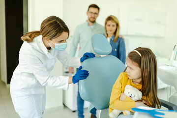 Obraz premium Child looking scared at female dentist sitting in dental chair.