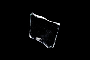 glass fragments in isolation on a black background. damaged window. damaged object