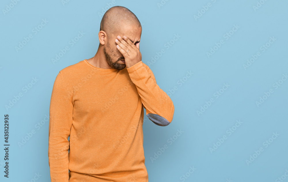 Wall mural Hispanic adult man wearing casual winter sweater tired rubbing nose and eyes feeling fatigue and headache. stress and frustration concept.