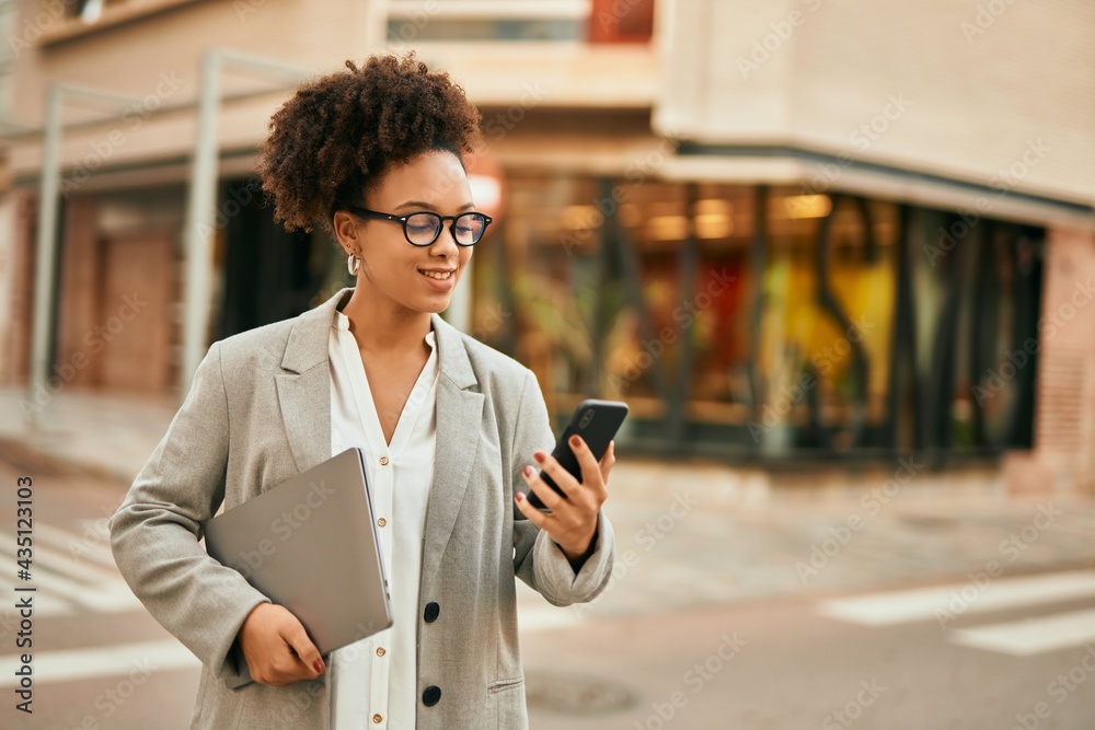 Canvas Prints Young african american businesswoman smiling happy using smartphone at the city.