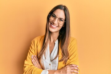 Young beautiful woman wearing business style and glasses happy face smiling with crossed arms looking at the camera. positive person.