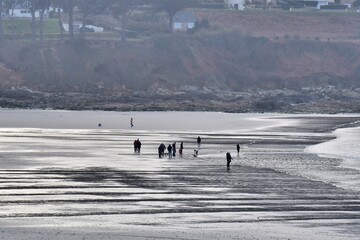 Fototapeta na wymiar People walking on a beach in Brittany
