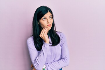 Young hispanic woman wearing casual clothes with hand on chin thinking about question, pensive expression. smiling with thoughtful face. doubt concept.
