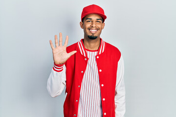 Young african american man wearing baseball uniform showing and pointing up with fingers number five while smiling confident and happy.