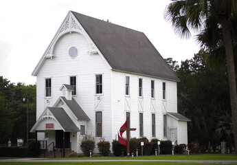 Old church in Ocala, Florida U.S.A. Built in 1844, renovated with white latticework, on highway 328 between Dunnellon and Ocala.  St. John’s United Methodist church, selective focus - obrazy, fototapety, plakaty