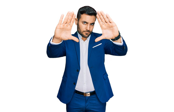 Young hispanic man wearing business jacket doing frame using hands palms and fingers, camera perspective