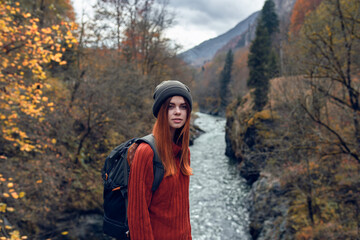 woman hiker with backpack in the mountains autumn forest river landscape