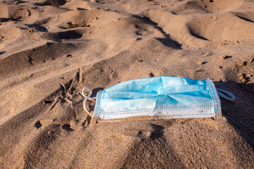 Mask thrown and abandoned in the sand on the beach.