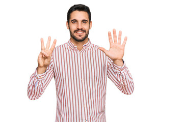 Young hispanic man wearing business shirt showing and pointing up with fingers number eight while smiling confident and happy.