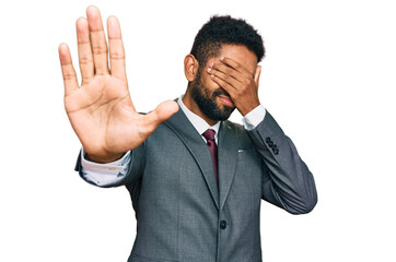 Young african american man wearing business clothes covering eyes with hands and doing stop gesture with sad and fear expression. embarrassed and negative concept.