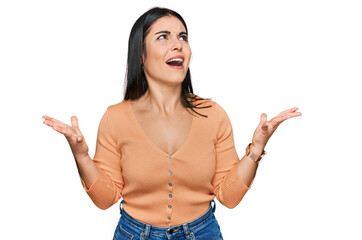 Young hispanic woman wearing casual clothes crazy and mad shouting and yelling with aggressive expression and arms raised. frustration concept.