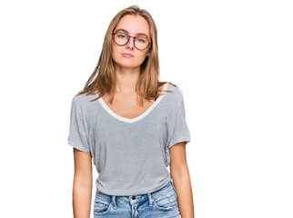 Beautiful young blonde woman wearing casual clothes and glasses relaxed with serious expression on face. simple and natural looking at the camera.