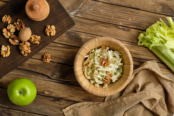 Waldorf salad with rustic ingredients on a wooden background