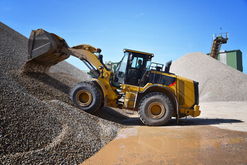 heavy construction machine in open-cast mining - wheel loader transports gravel in a gravel plant