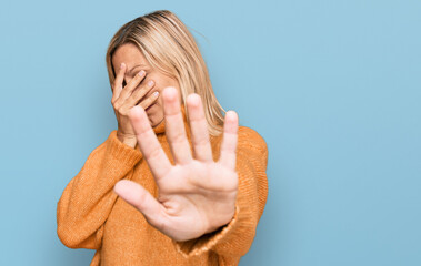 Middle age caucasian woman wearing casual winter sweater covering eyes with hands and doing stop gesture with sad and fear expression. embarrassed and negative concept. - obrazy, fototapety, plakaty
