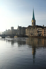 Fototapeta premium Wonderful day for sightseeing: Limmat river promenade in Zurich, Switzerland. Fraumuenster church.